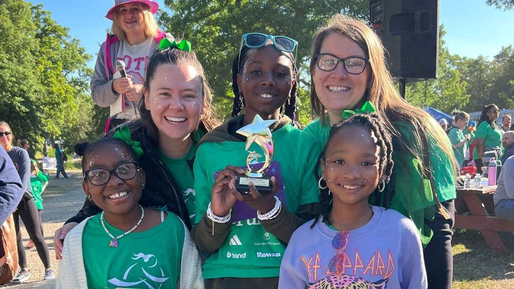 Teacher and students hold up their award