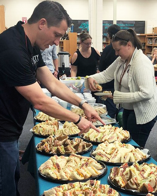 Parents setting up a buffet lunch for teachers
