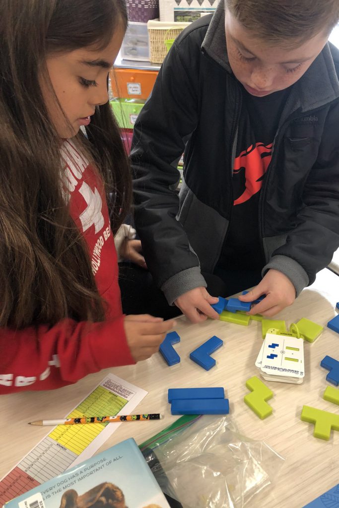 Two students working together connecting shapes