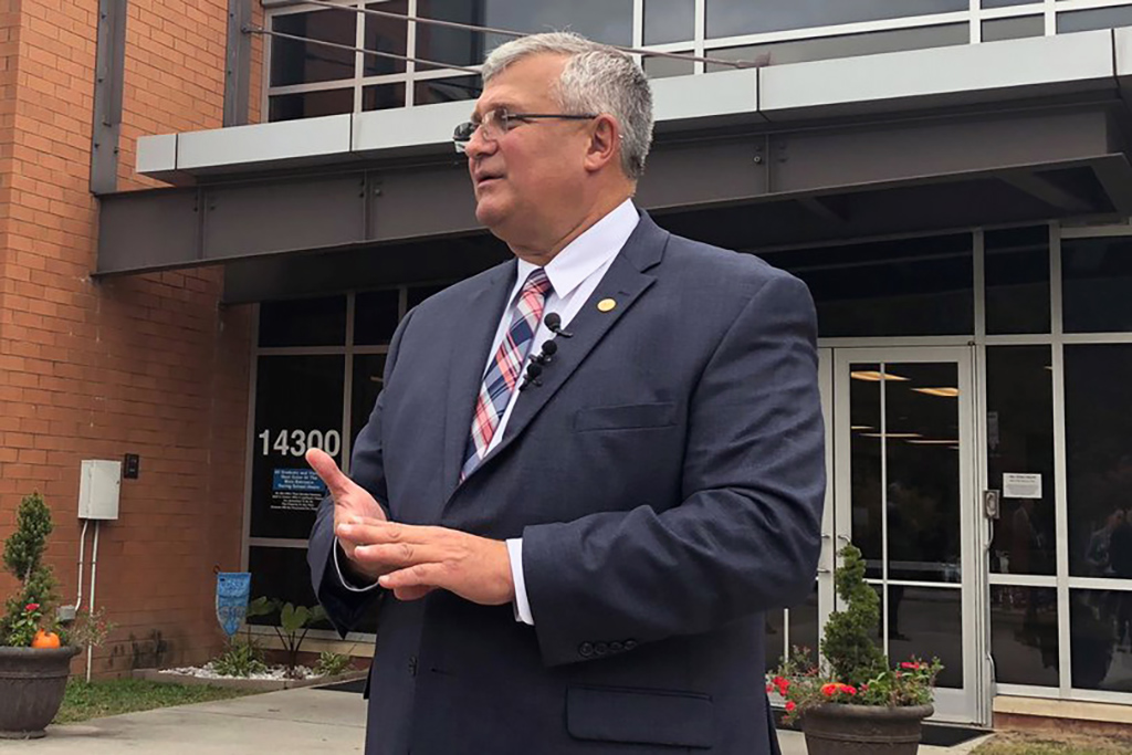Candid photo of Mr. D in front of a school building