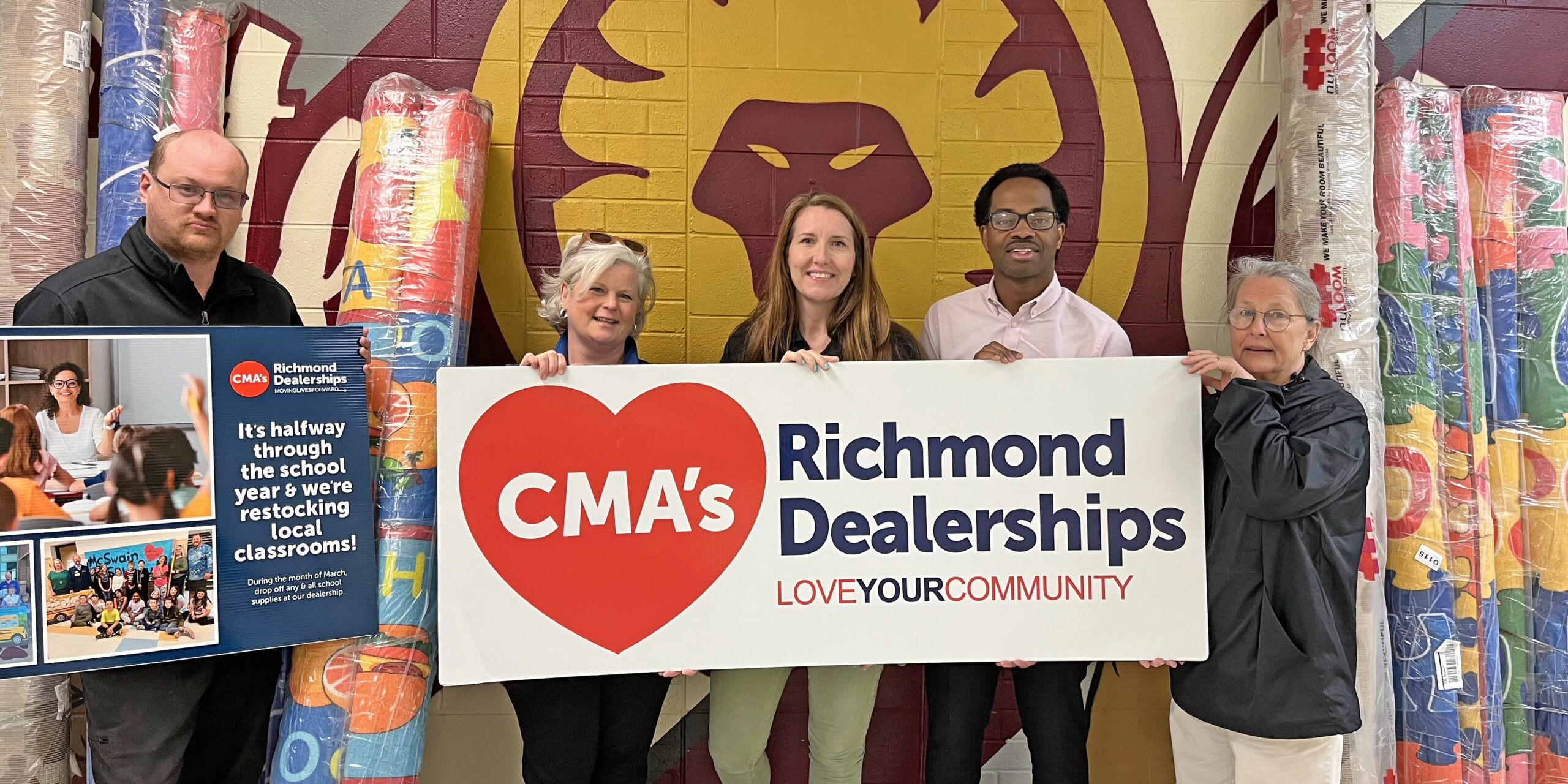Four adults holding up a CMA Richmond Dealership sign.