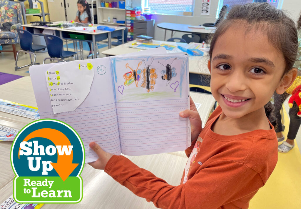 Child facing the camera holding a book