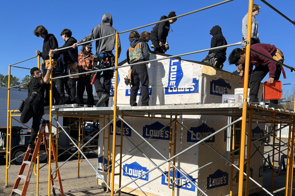 Students learning to put a roof on a shed