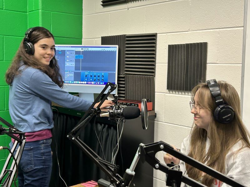 Two high school girls working on recording equipment