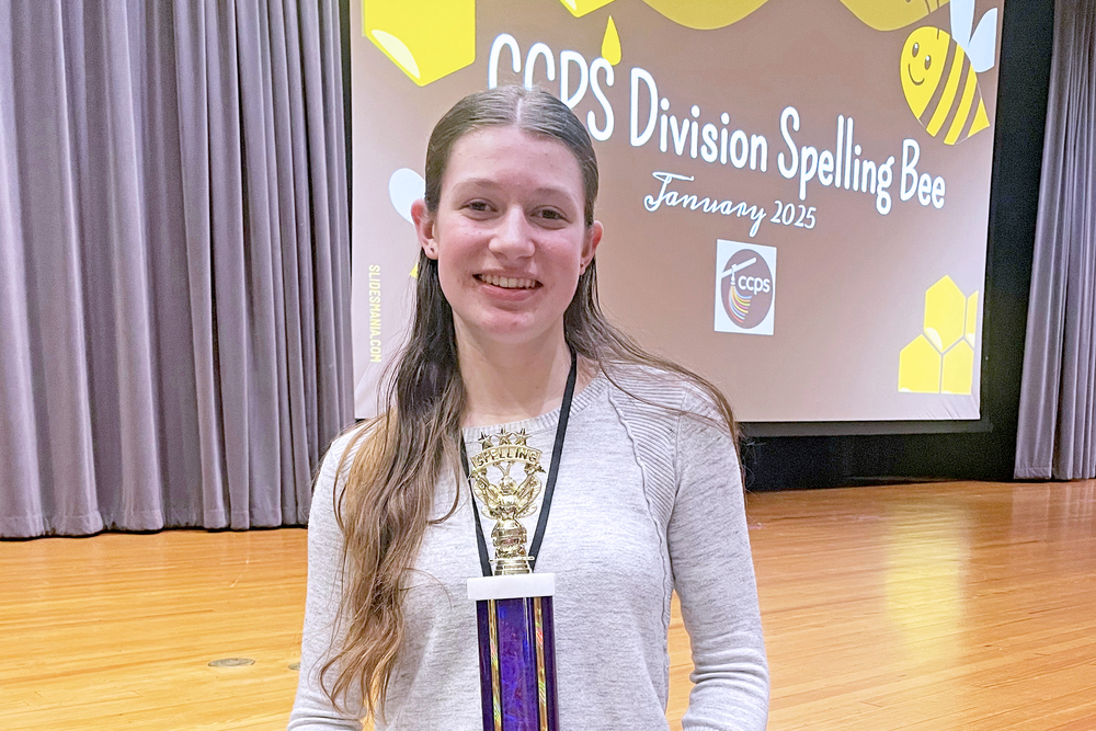 student holds up award