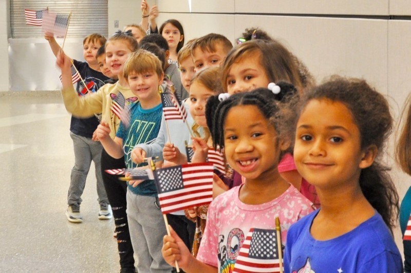 Kids lined up holding American flags