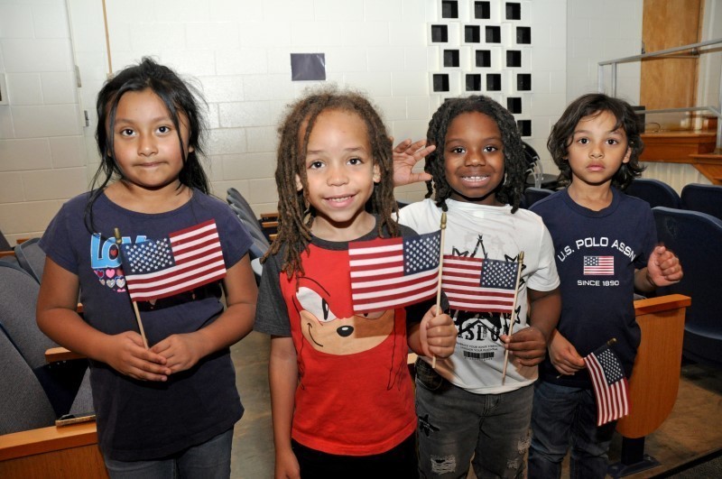 Four students holding American flags