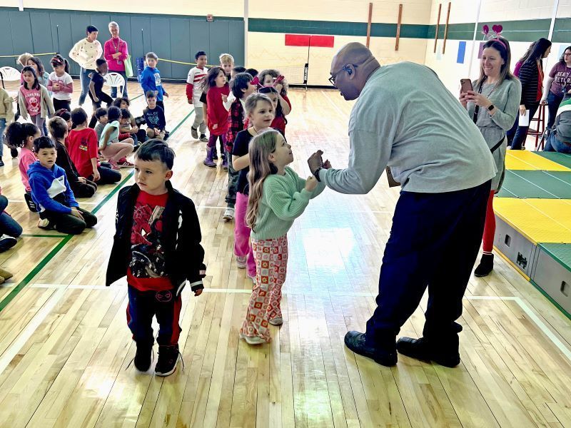 Mr. Jones fist-bumping a young girl