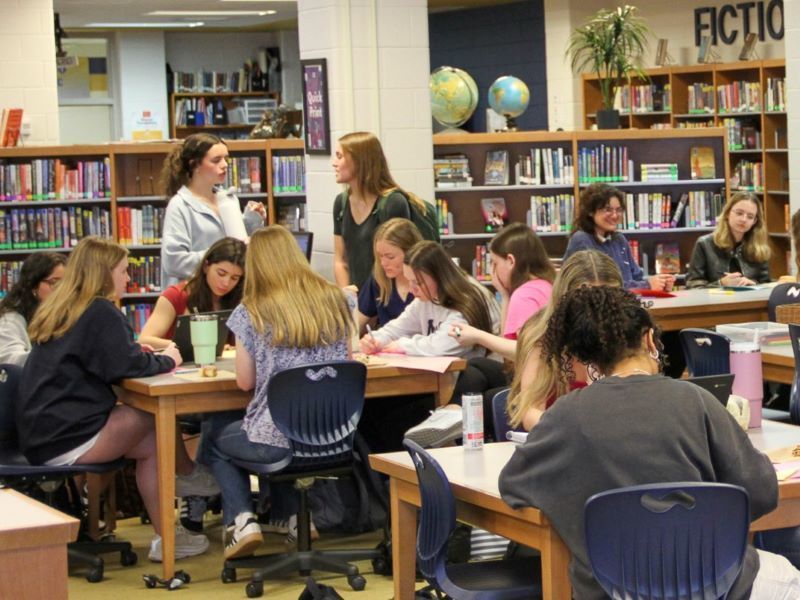 A library full of students making cards