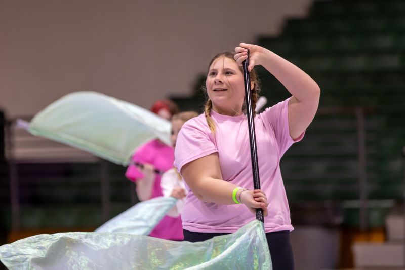A young student twirling a flag