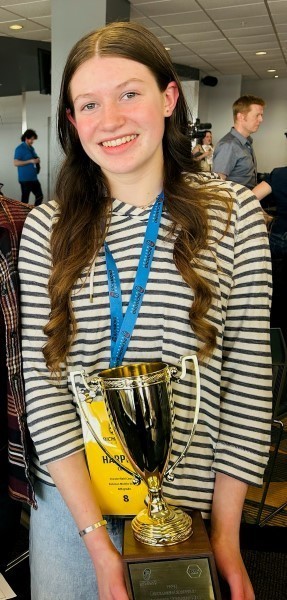 Harper C. holding her spelling trophy