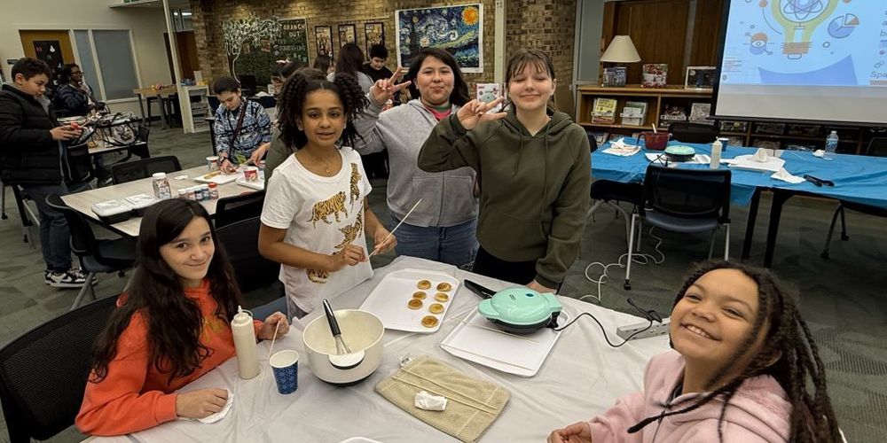 Student smiling while making donuts