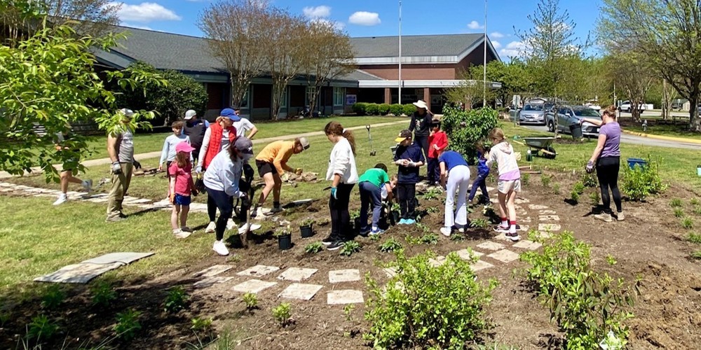 Students and families planting at Bettie Weaver