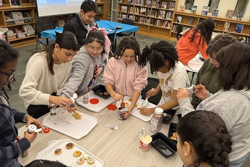 Student making donuts in the library