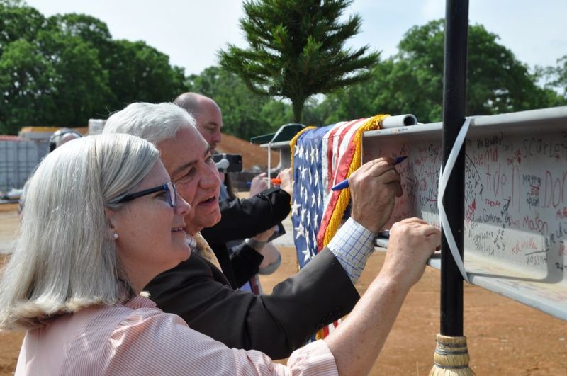 County and school leaders sign the beam