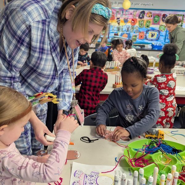 Teacher helping students make gingerbread people