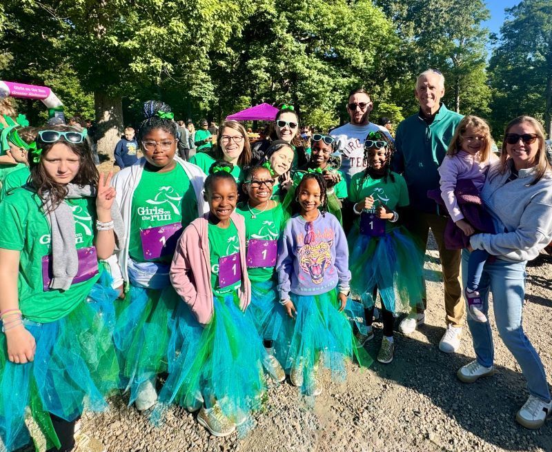 Students in colorful outfits posing with Jody Enoch's family