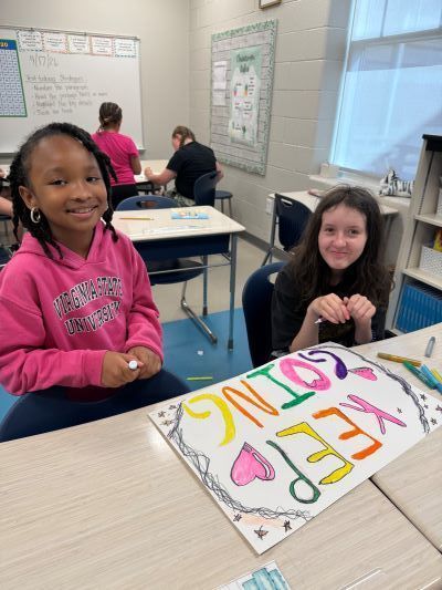 Two girls making a colorful inspirational poster