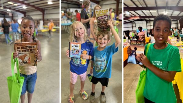Children holding books at an indoor event.
