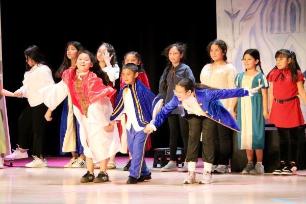 Kids in colorful costumes bowing