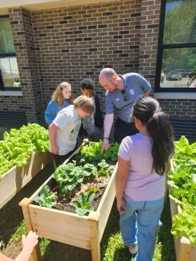 Dr. John Murray looking at plant beds with students