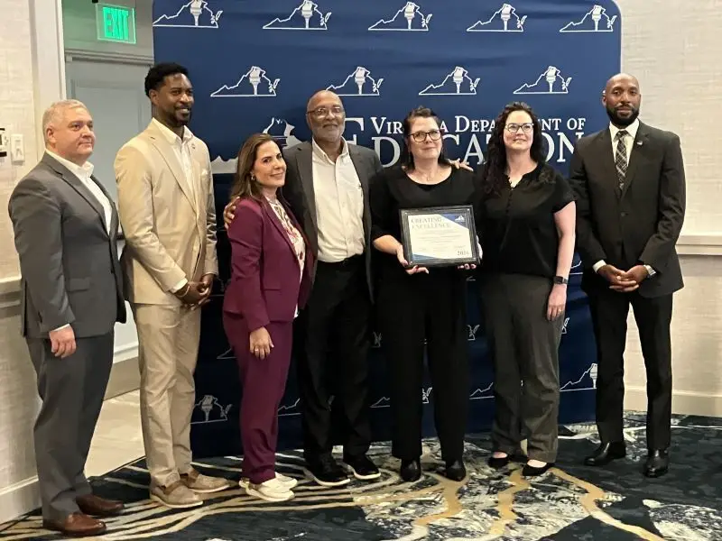 A group of people in suits holding an award