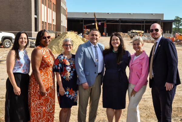 Group of people smiling at construction site.