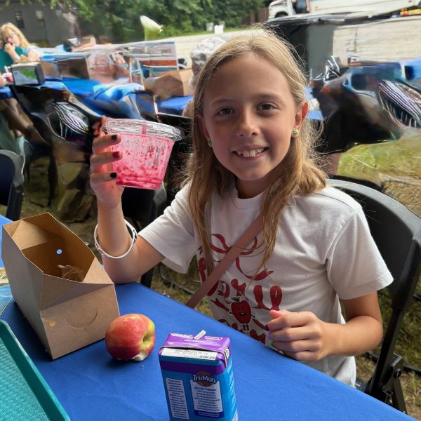 Girl with dessert, apple, milk at table. Girl with dessert, apple, milk at table.