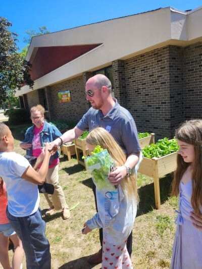 Dr. John Murry shaking hands with a student