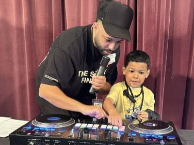 Man teaching boy to use DJ equipment. Man teaching boy to use DJ equipment.