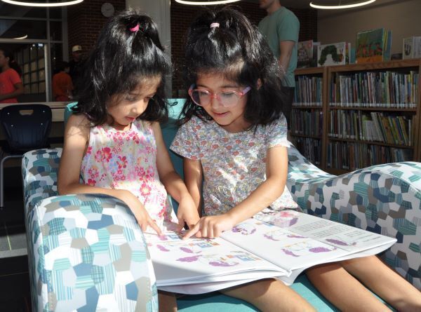 Two girls reading a book in the school library