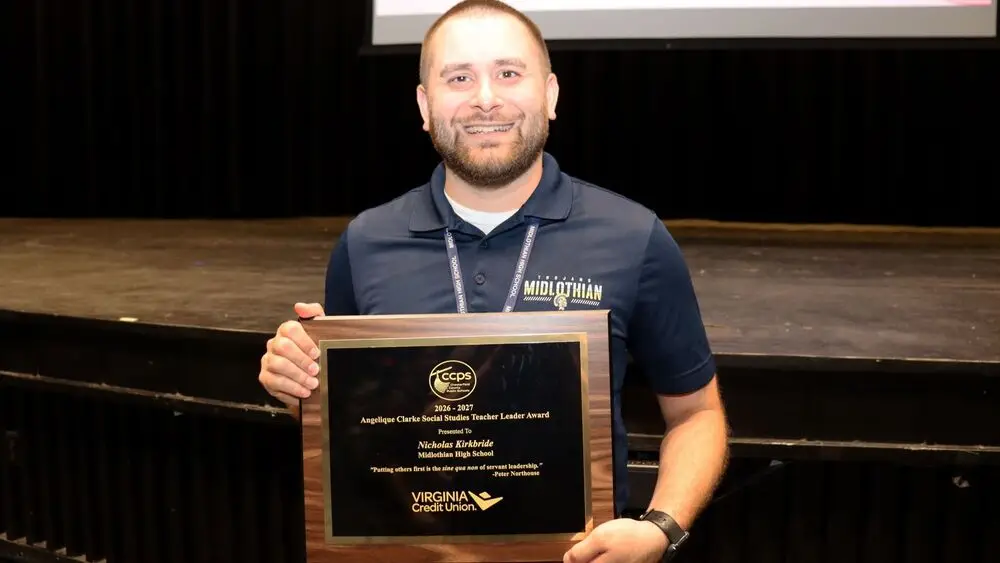 Teacher holding up award.